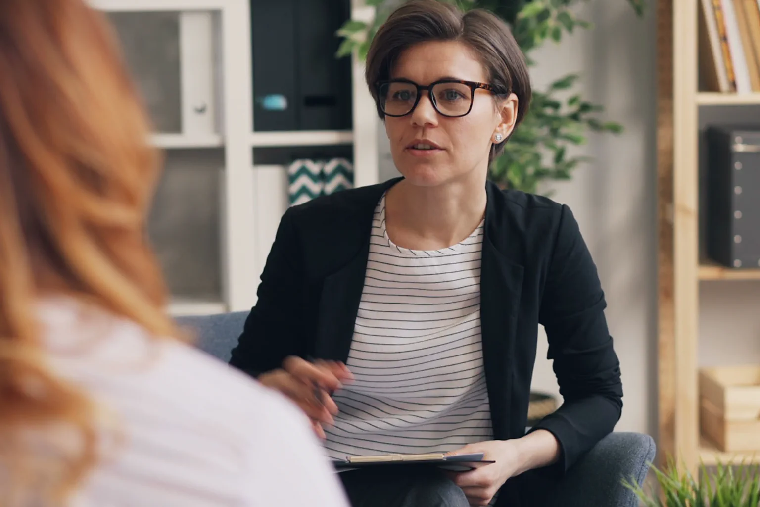 Mujer adulta conversa con una profesional durante una sesión de apoyo psicológico.
