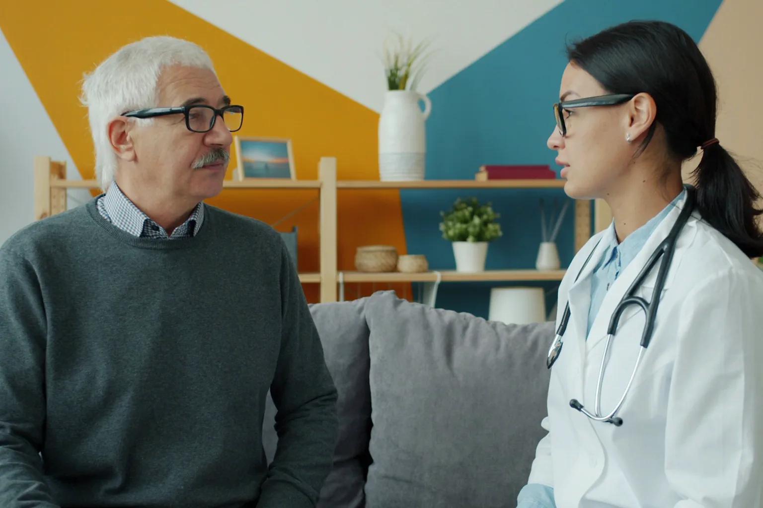Persona adulta conversa con una médica durante una consulta de seguimiento.