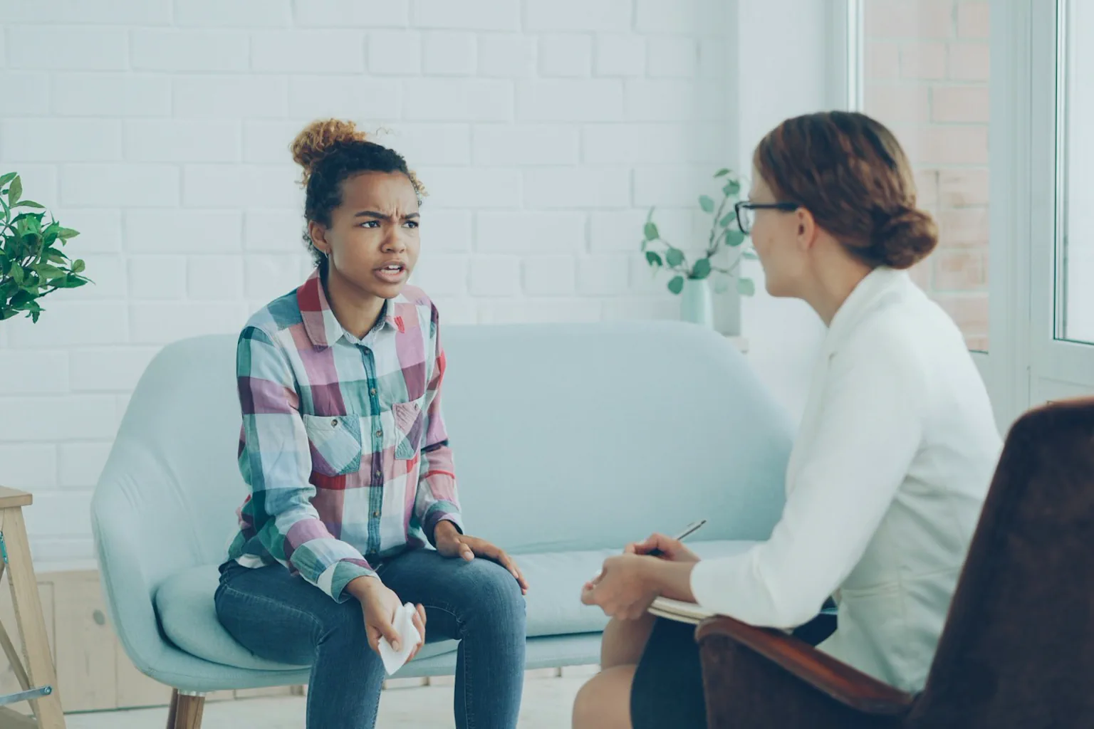 Mujer adulta conversa con una profesional durante una sesión de orientación.